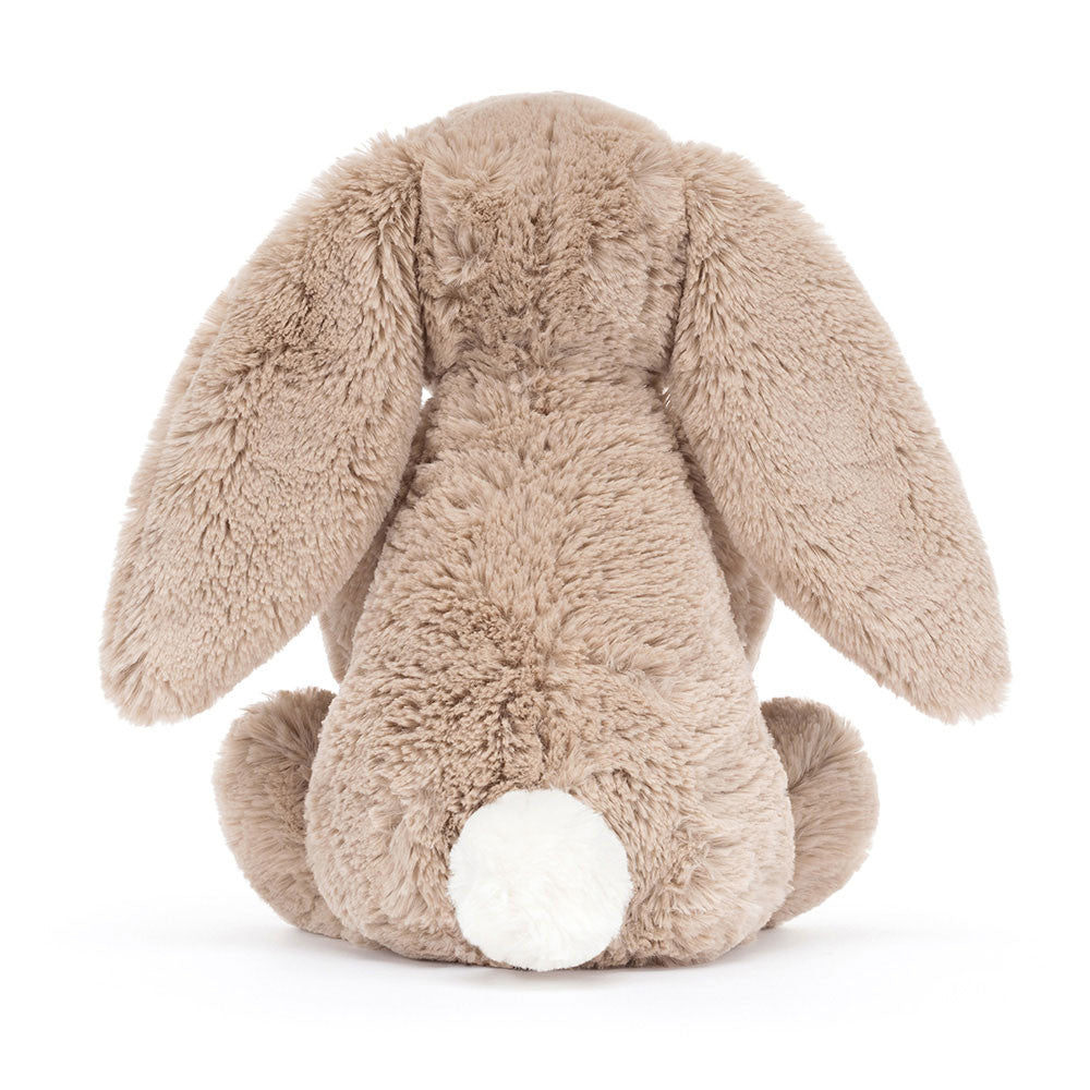 Rückansicht: Jellycat Bashful Beige Bunny Birthday – sitzender beiger Kuscheltier-Hase mit Hängeohren und kleinem Geburtstagskuchen und Kerze in den Pfoten.