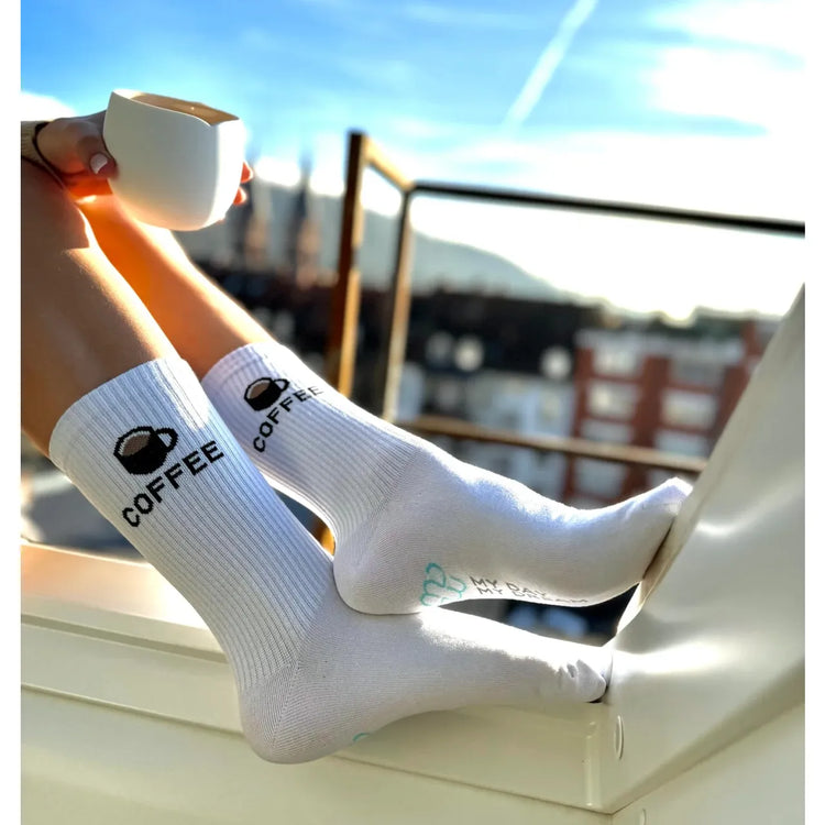 Socken von My Day My Dream. Mit der Aufschrift COFFEE und einer Tasse mit Kaffee gefüllt.