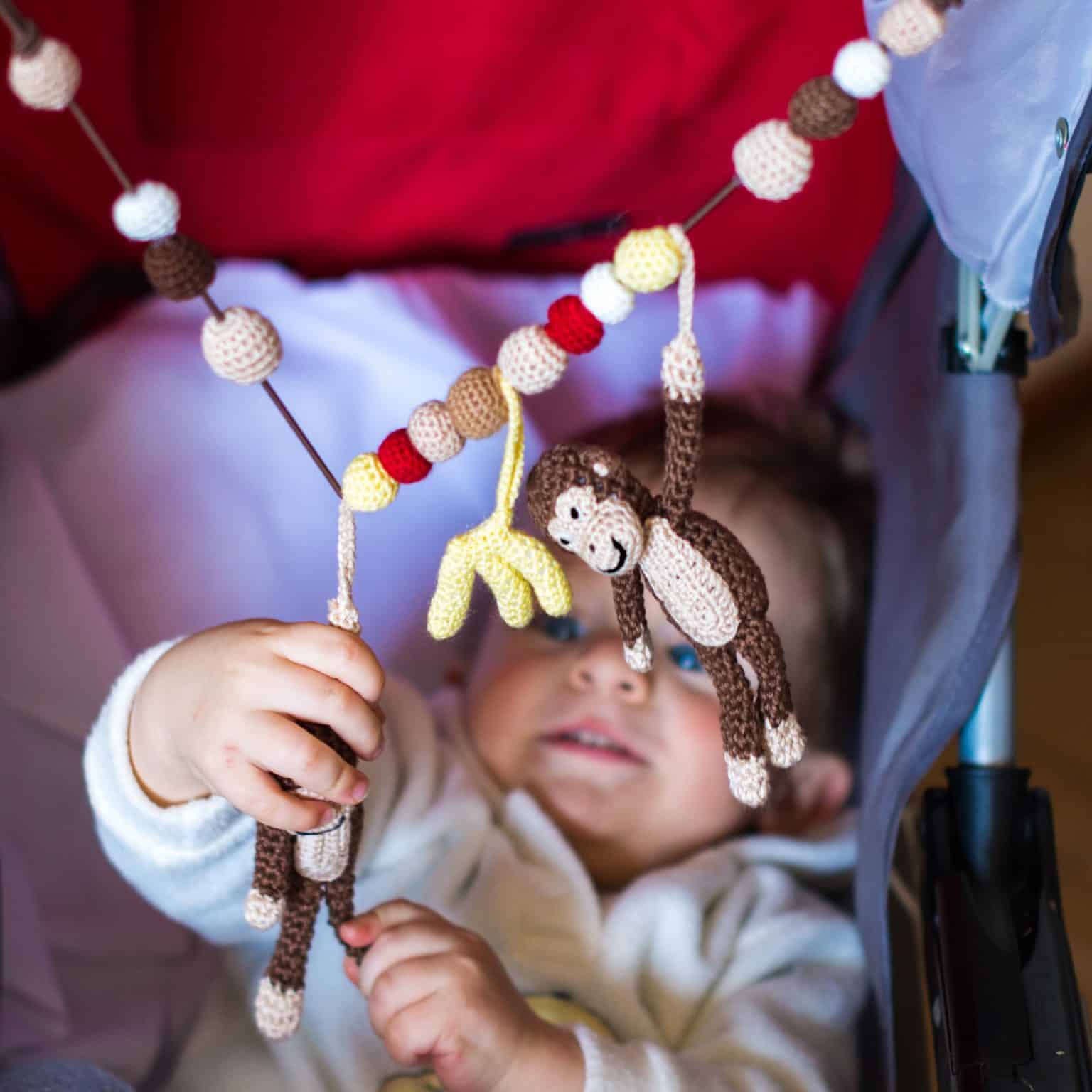 Kinderwagenkette von Sindibaba mit gehäkelten Affen.