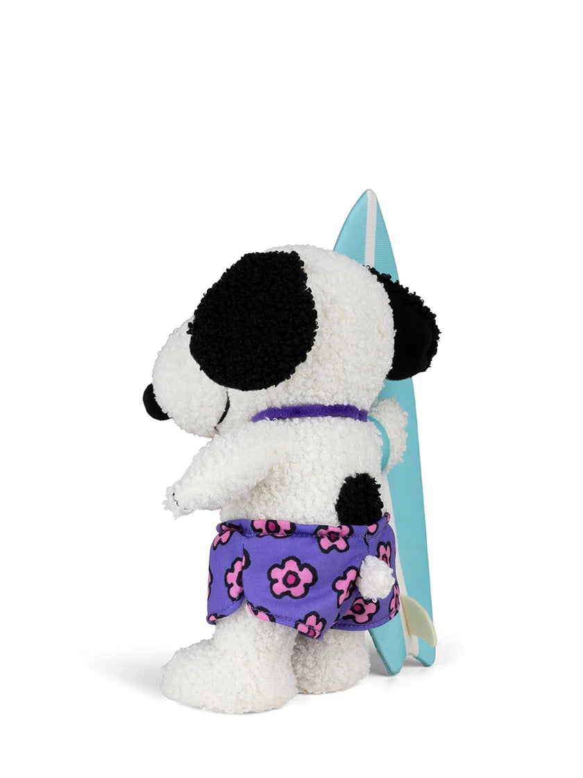 Snoopy ist am Strand mit seinem Surfbrett unterwegs.