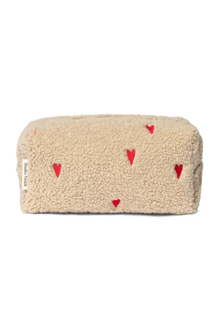 Mit Herzen bestickte Kulturtasche aus Teddystoff von Studio Noos.