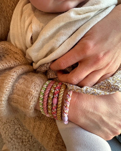 KKNEKKI Haargummi Coral Glitter – geflochtenes Haargummi als trendiges Armband zusammen mit weiteren Farben getragen
