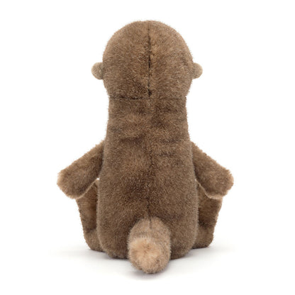 Braunes Jellycat Brooke Otter Kuscheltier sitzt kerzengerade am Ufer und schaut aufmerksam in die Umgebung, wirkt wie ein kleiner Wächter der Flusslandschaft