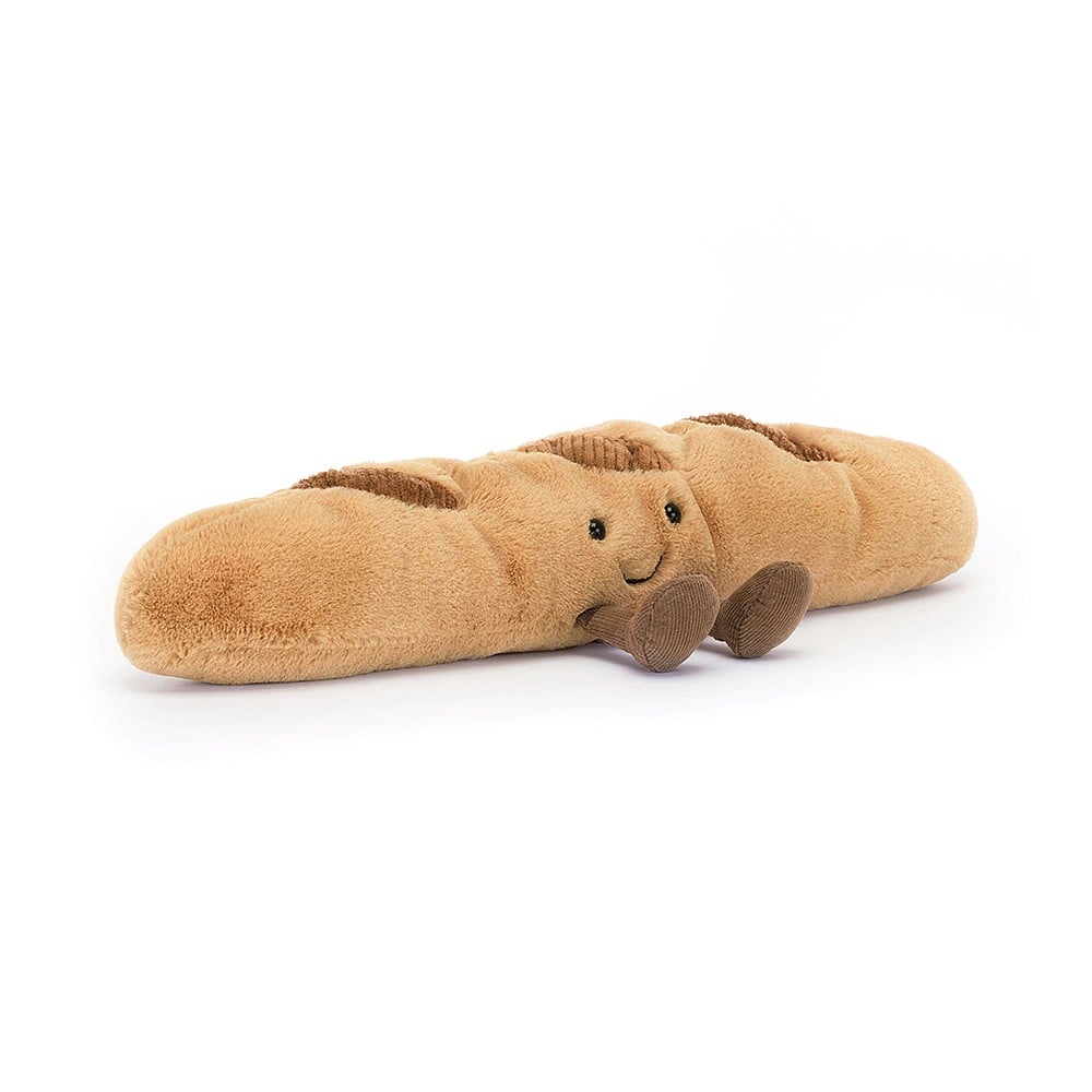 Braunes Plüsch-Croissant mit Lachgesicht streckt kleine beinchen von sich