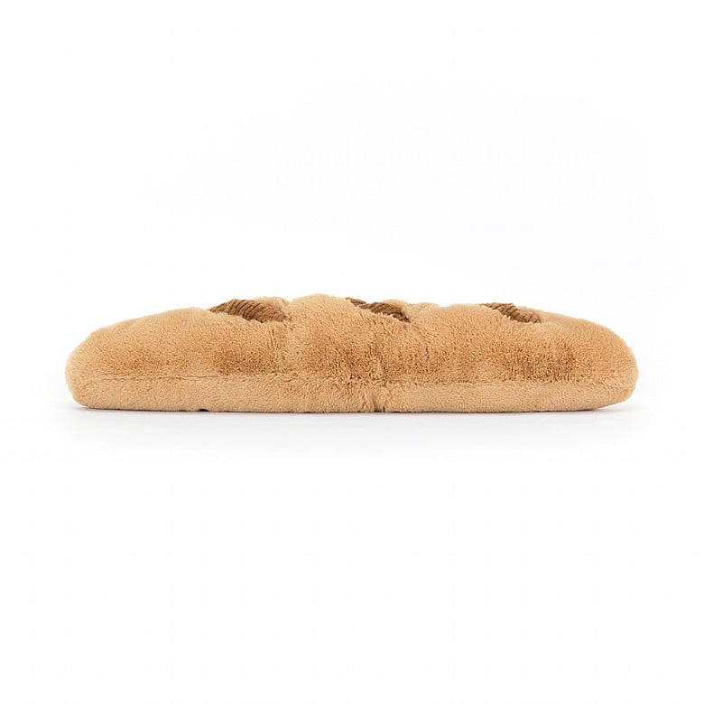 Braunes Plüsch-Croissant mit Lachgesicht streckt kleine beinchen von sich