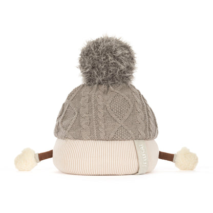 Jellycat Amuseables Pomilly Strickmütze in Grau mit großem Flausch-Bommel und behandschuhten Händen von hinten