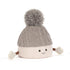Jellycat Amuseables Pomilly Strickmütze in Grau mit großem Flausch-Bommel, behandschuhten Händen und lachendem Gesicht von vorne