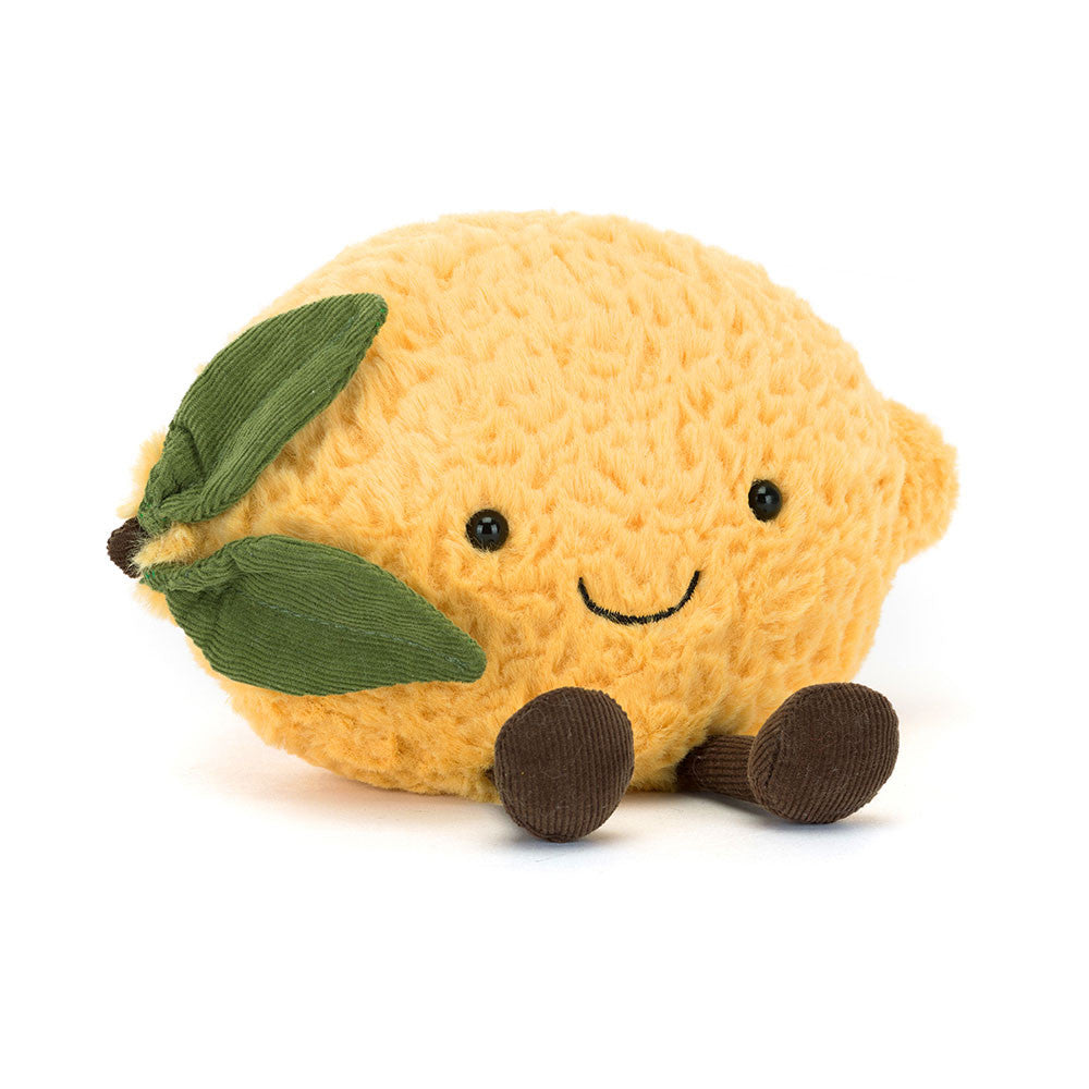Jellycat Amuseables Lemon Kuscheltier in Form einer gelben Zitrone mit Gesicht, kleinen Füßen und Zitronenblatt, sitzende Position.