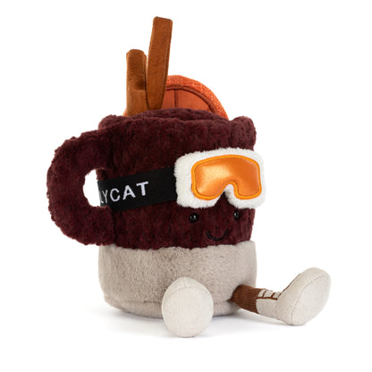 Jellycat Amuseables Mullover Spiced Drink sitzend mit Füßchen, Skibrille, Ohrenschützern, Zimtstange, Orangenscheibe und lachendem Gesicht von vorne