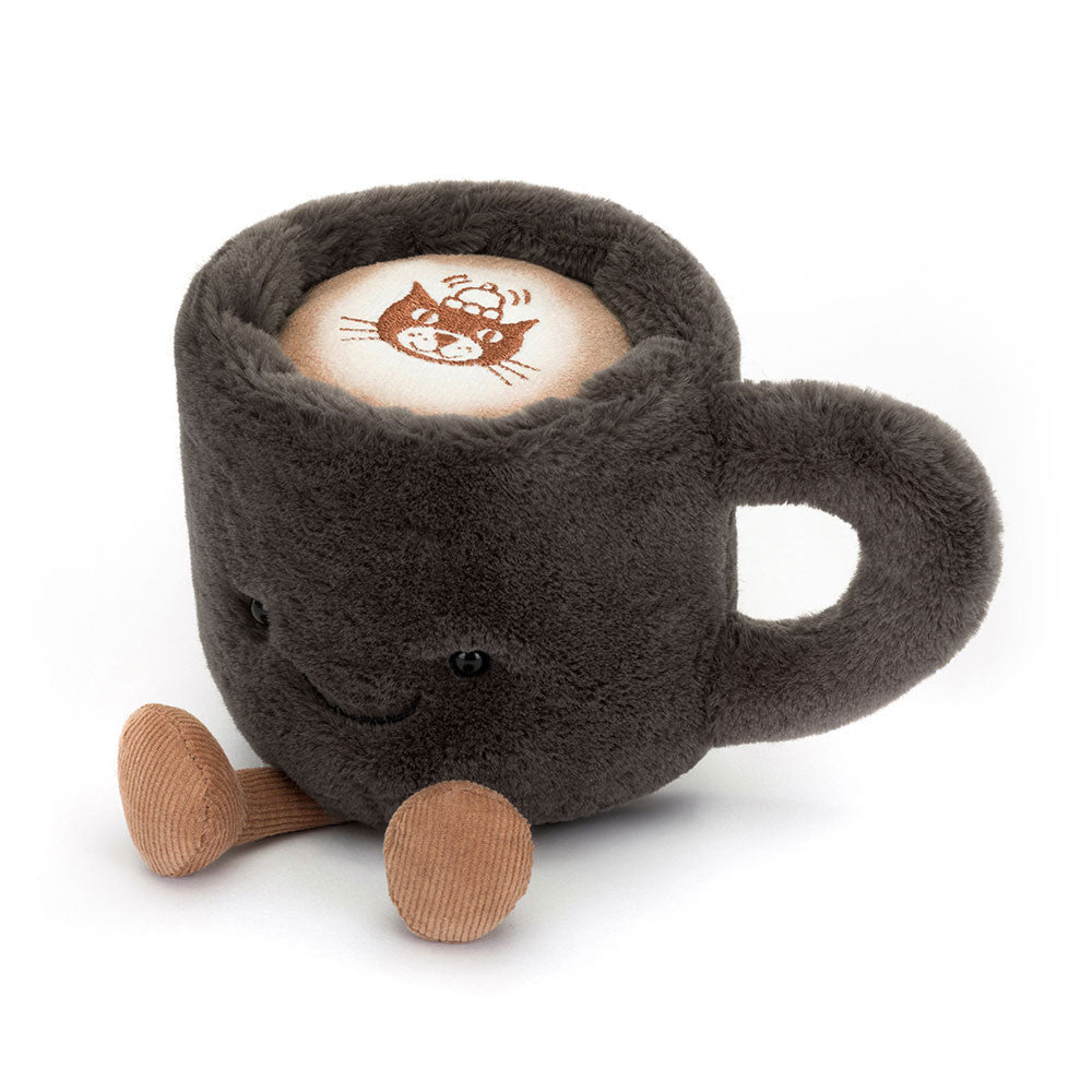 Jellycat Amuseables Coffee Cup – kuschelweiche, dunkelgraue Kaffeetasse mit lächelndem Gesicht und kleinen Beinchen, sitzend von vorne. Mit Jellycat-Logo auf der Oberseite.