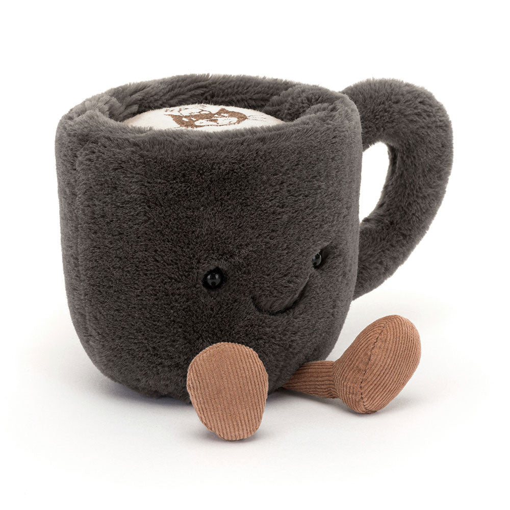 Jellycat Amuseables Coffee Cup – kuschelweiche, dunkelgraue Kaffeetasse mit lächelndem Gesicht und kleinen Beinchen, sitzend von vorne.