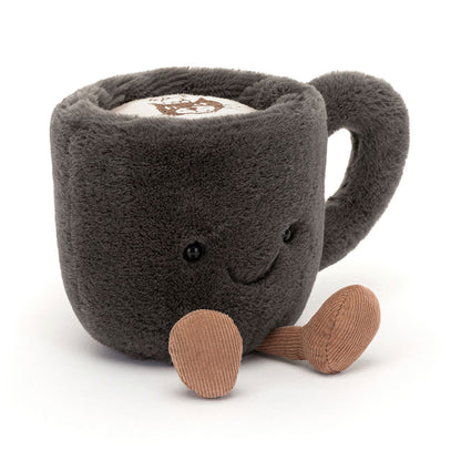 Jellycat Amuseables Coffee Cup – kuschelweiche, dunkelgraue Kaffeetasse mit lächelndem Gesicht und kleinen Beinchen, sitzend von vorne.