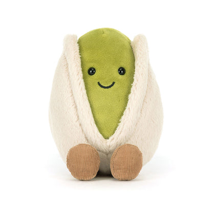 Voderansicht Jellycat Amuseables Pistachio – sitzende grüne Plüsch-Pistazie mit lachendem Gesicht und schwarzen Knopfaugen, die aus einer hellbeigen Hülle schaut und hellbraune Füßchen hat.