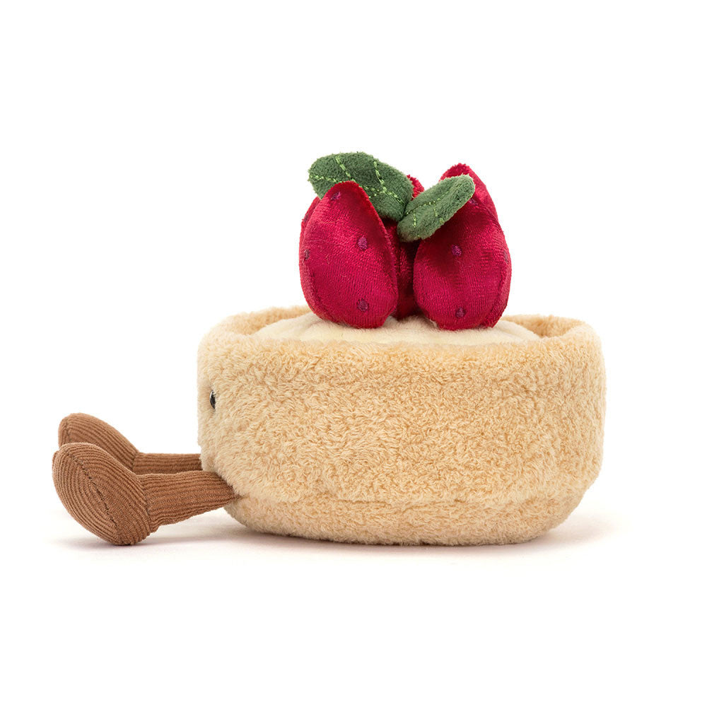 Jellycat Amuseables Fleurette Tarte Aux Fraises von der Seite mit hellem Tortenboden, Cremefüllung und roten Erdbeeren.