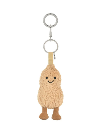 Jellycat Amuseables Peanut – kuscheliger Erdnuss Schlüssel- und Taschenanhänger mit kleinen Beinchen, lächelndem Gesicht und silbernem Befestigungsring, von vorne.