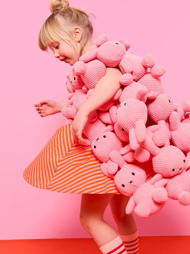 Mädchen trägt viele Miffy ECO Corduroy aus Cord in der Farbe Bubblegum Pink, 23 cm in den Armen