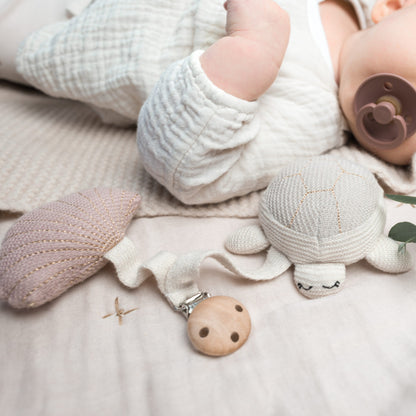 Kinderwagenanhänger Tily die Meeresschildkröte von Baby Bello. Sie hat ein kleines Glöckchen im Bauch und macht leise Geräusche bei Bewegung.