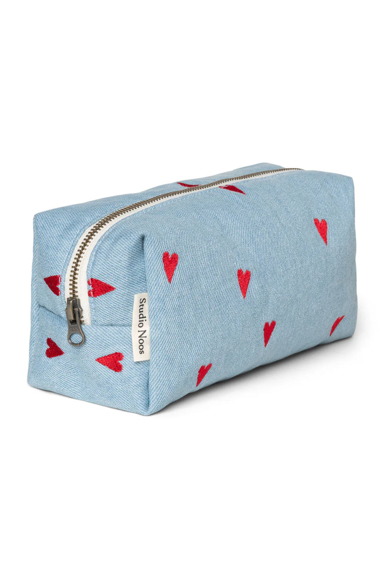 Mit Herzen bestickte Kulturtasche aus Denim von Studio Noos. 