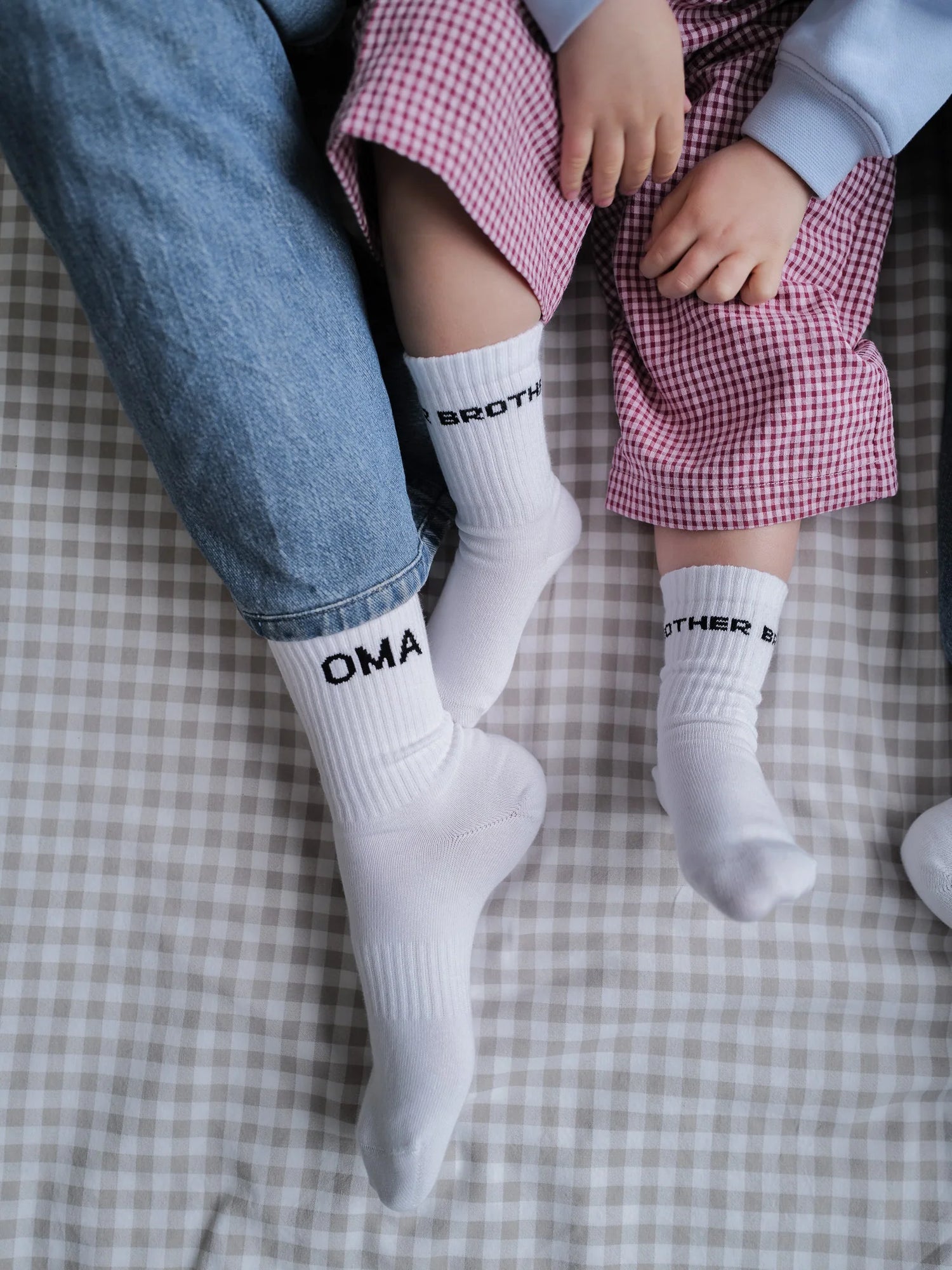 Weisse Socken von FAMVIBES mit schwarzem Schriftzug OMA