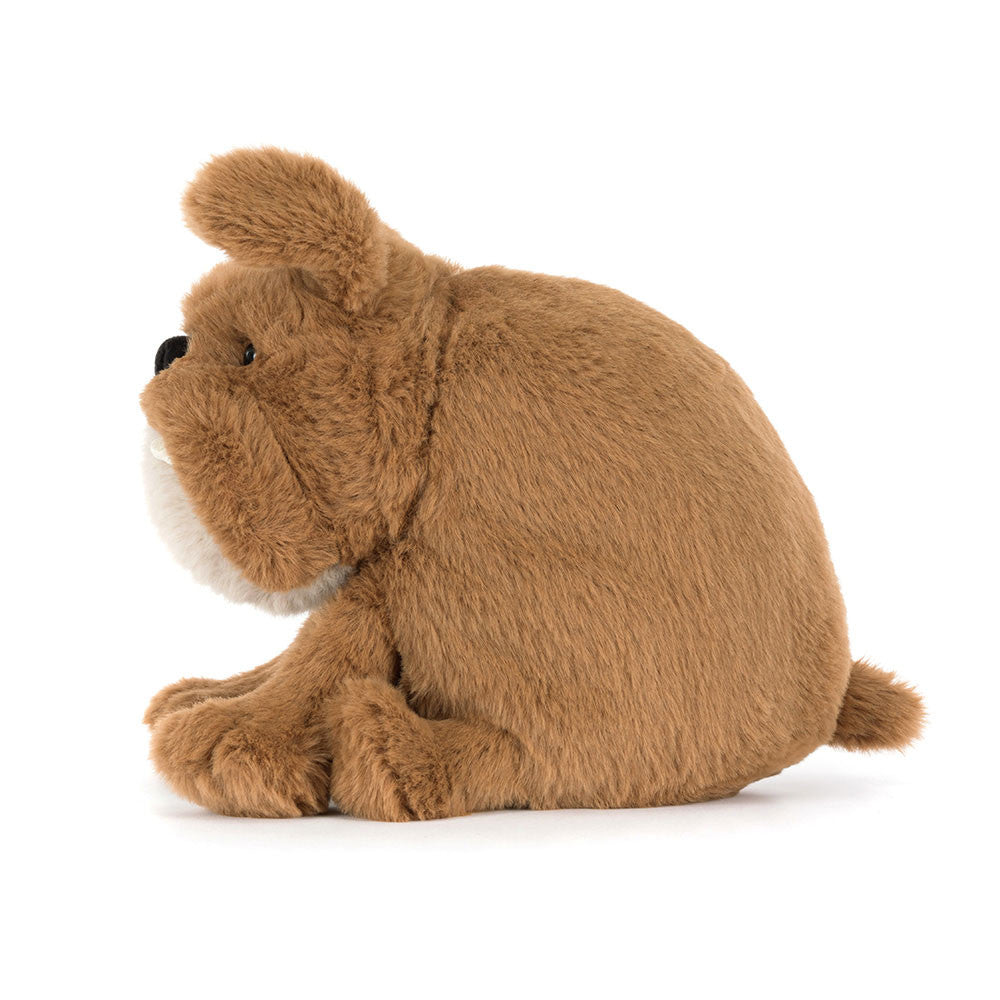 Seitenansicht: Jellycat Derreck Dog – sitzende hellbraune Plüsch-Bulldogge mit beigem Maul und Brust, grimmigem Gesichtsausdruck, kleinen Zähnchen und schwarzen Knopfaugen.