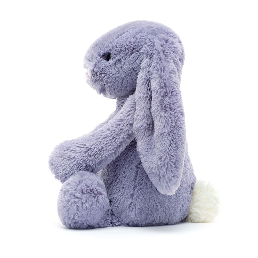 Seitenansicht: Jellycat Bashful Viola Bunny, violetter Plüschhase mit langen Hängeohren, weißem flauschigem Schwänzchen und niedlichem Gesicht