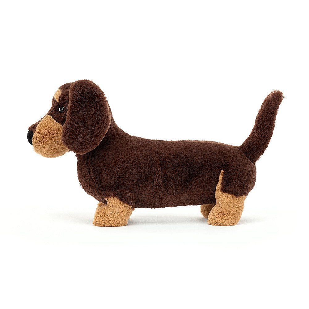 Seitenansicht: Jellycat Sausage Dog Otto – stehender Kuscheltier-Dackel in typischen Dackelfarben mit dunkelbraunem und hellbraunem Fell.
