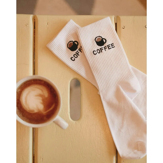 Socken von My Day My Dream. Mit der Aufschrift COFFEE und einer Tasse mit Kaffee gefüllt.