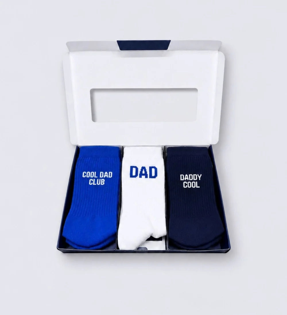 Geöffnete DAD Geschenkbox von No Bad Days Club mit drei Paar Herrensocken in Blau, Weiß und Dunkelblau.