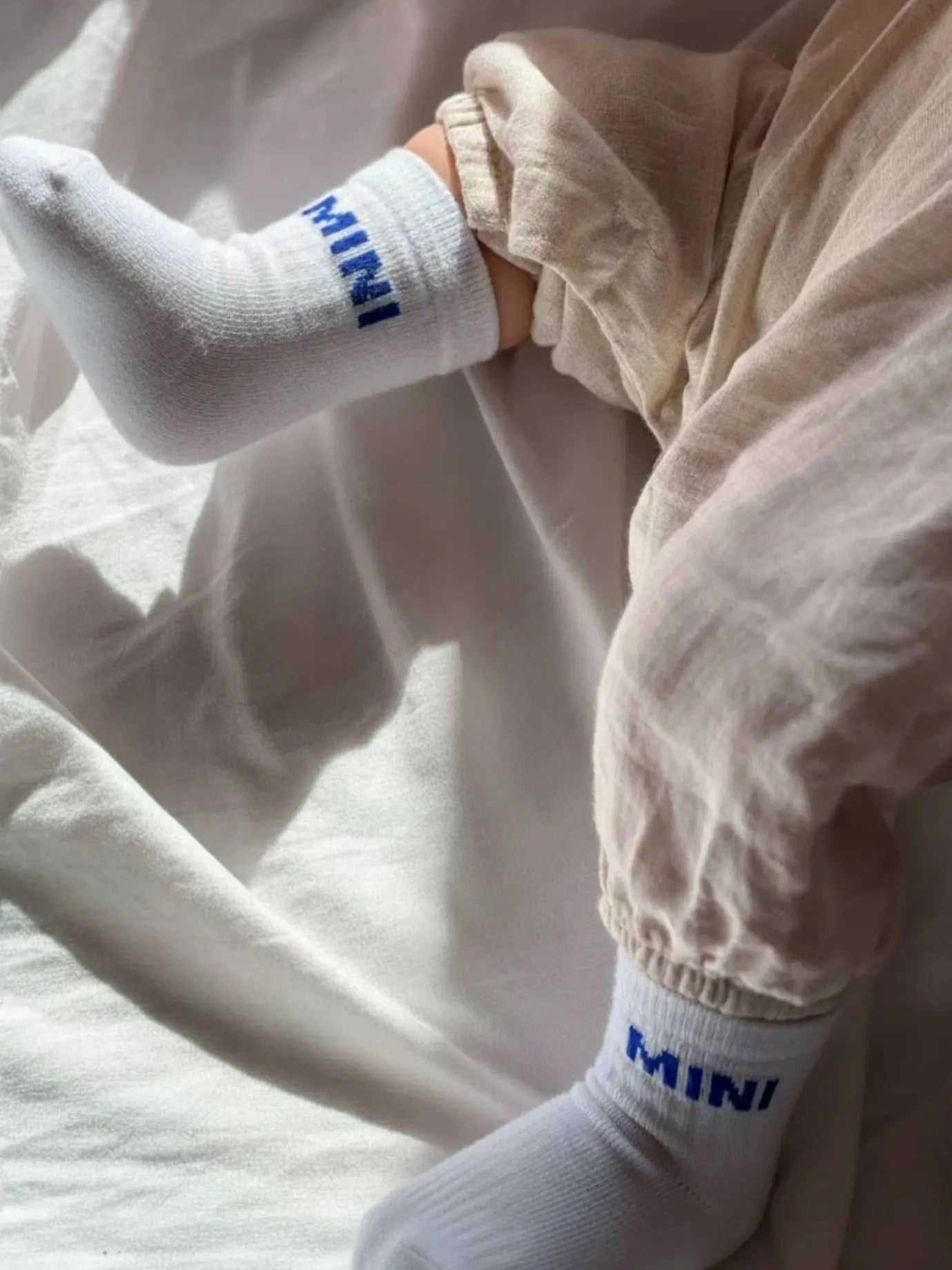 Babysocken "Mini" in Weiß mit blauem Schriftzug, aus Bio-Baumwolle, 0–1 Jahre. Tolles Geburtsgeschenk.