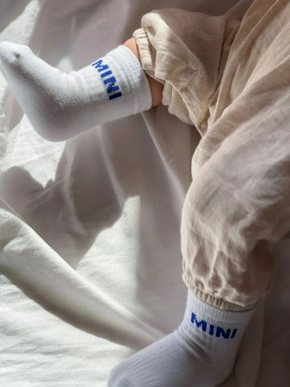 Babysocken "Mini" in Weiß mit blauem Schriftzug, aus Bio-Baumwolle, 0–1 Jahre. Tolles Geburtsgeschenk.