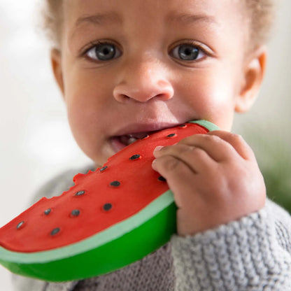 Kleiner Junge kaut auf dem Wally the Watermelon Beißring aus Naturkautschuk