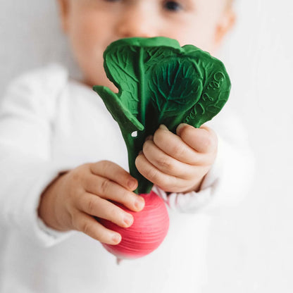 Ramona the Radish Beißring – Baby hält das Radieschen-Beißspielzeug aus Naturkautschuk in den Händen