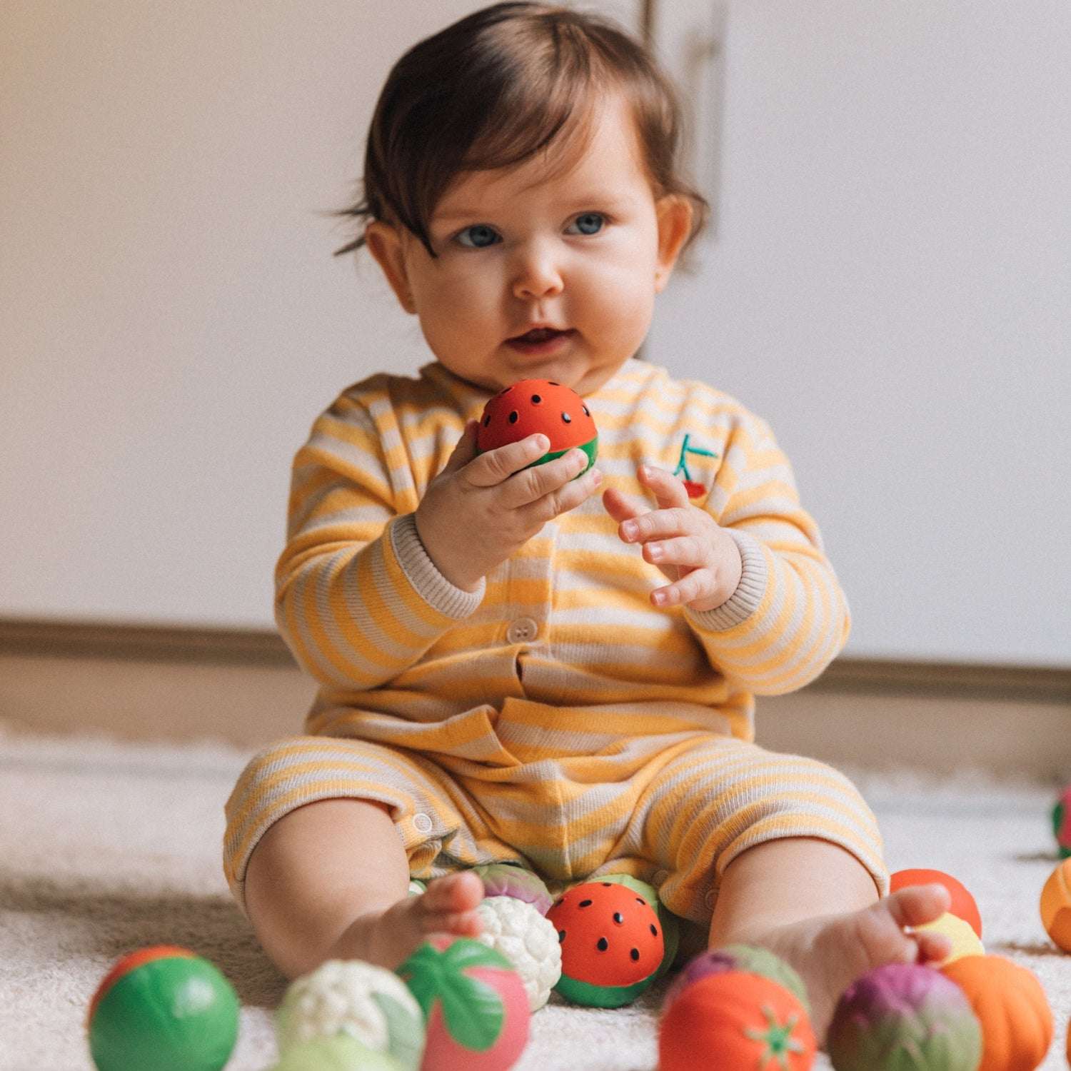 Baby spielt mit dem Wassermelonen-Sensorikball aus Naturkautschuk