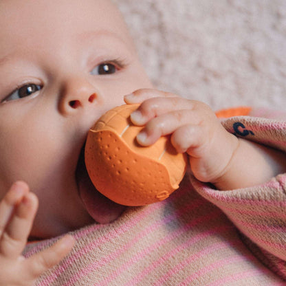 Baby kaut auf dem Mandarinen-Sensorikball aus Naturkautschuk
