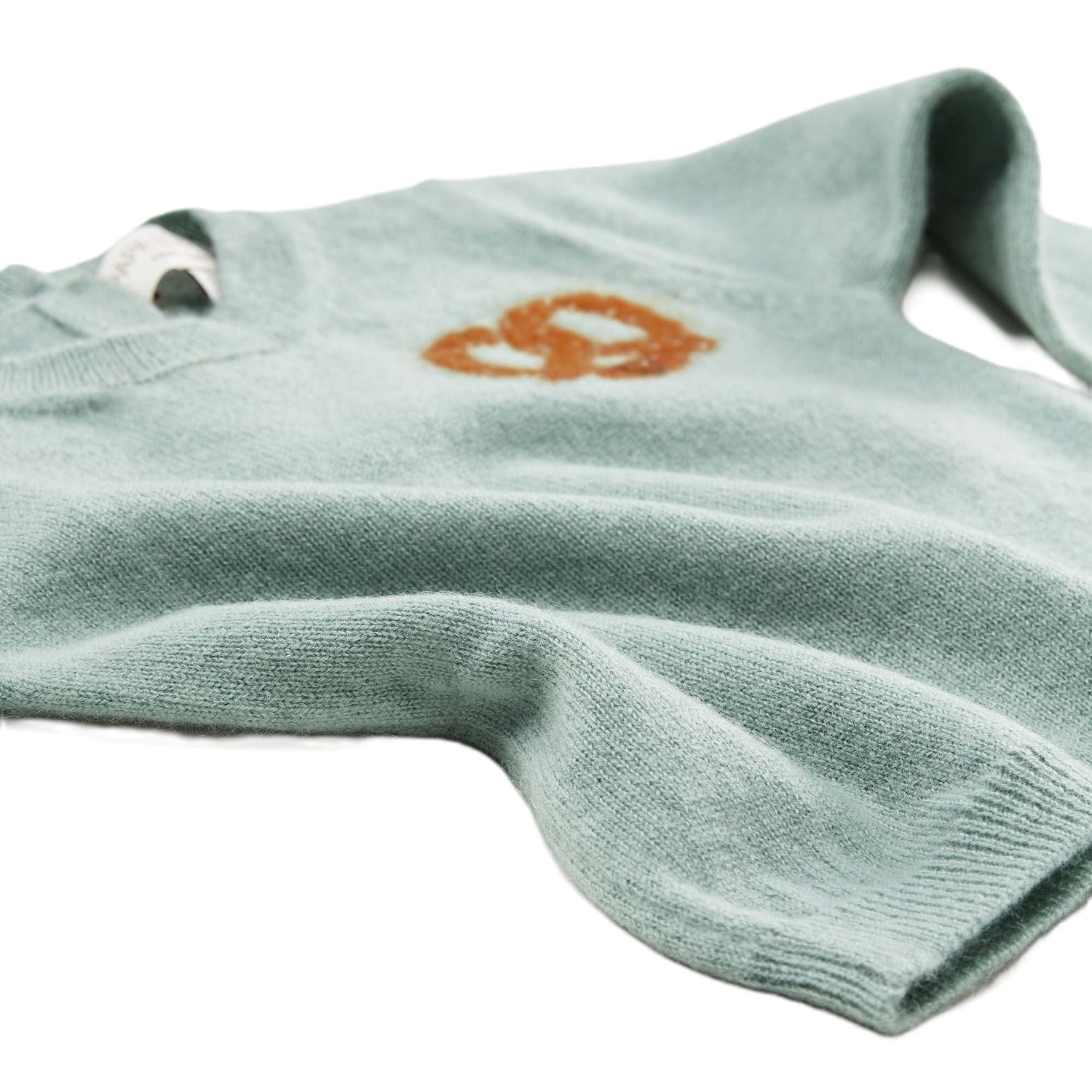 Detailansicht: Kaschmirpullover Brezel von PAPA LOBSTER in Salbei mit kleiner Brezel auf der Brust für Babys und Kinder