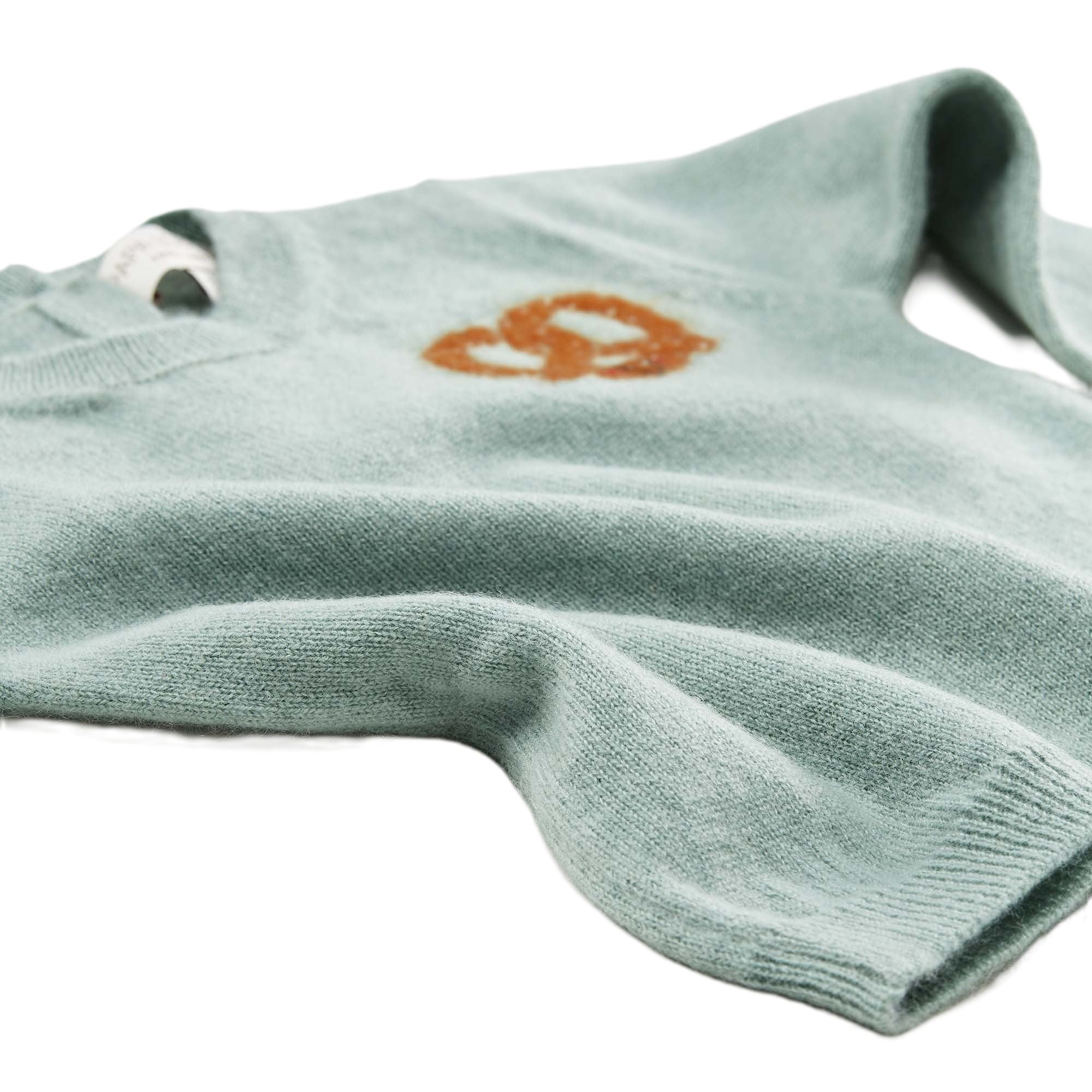 Detailansicht: Kaschmirpullover Brezel von PAPA LOBSTER in Salbei mit kleiner Brezel auf der Brust für Babys und Kinder