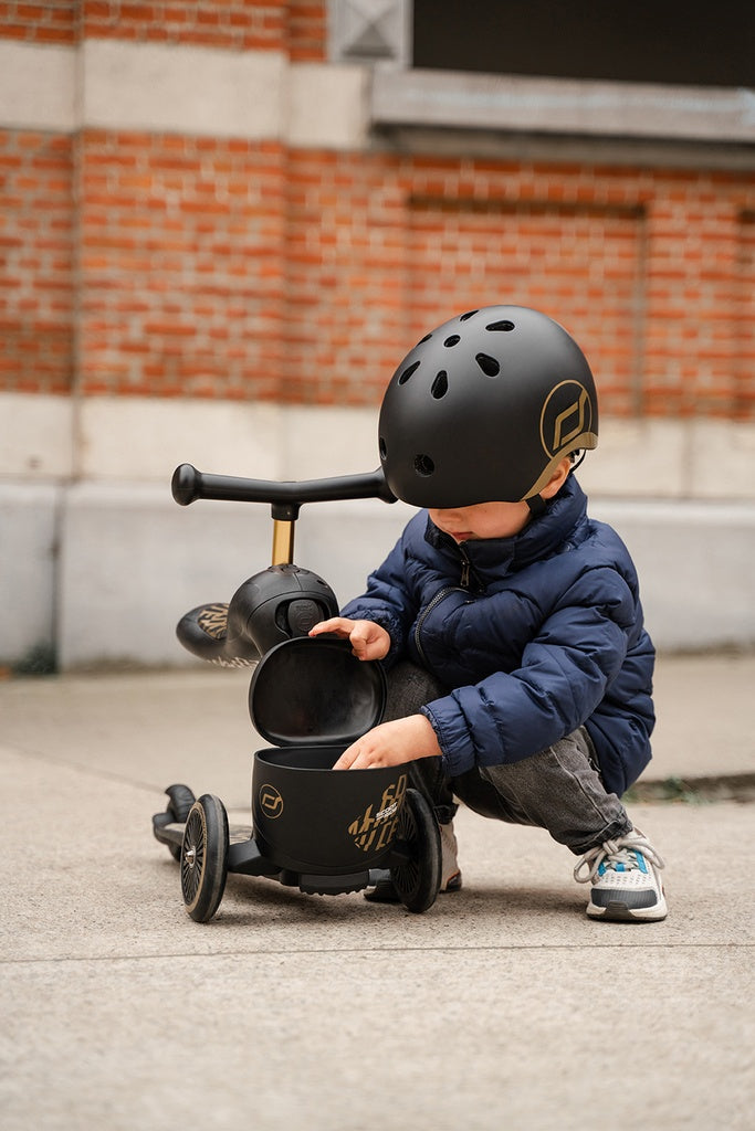 Kind packt Spielzeug in die Aufbewahrungsbox des Scoot and Ride Highwaykick 1 Lifestyle Kinderrollers