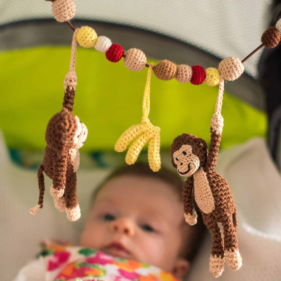 Kinderwagenkette von Sindibaba mit gehäkelten Affen.