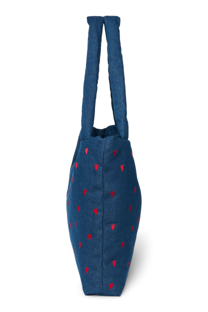 Seitenansicht der Studio Noos Mom-Bag aus dunkelblauem Denim mit wattierten Henkeln, gestickten roten Herzen und Logo