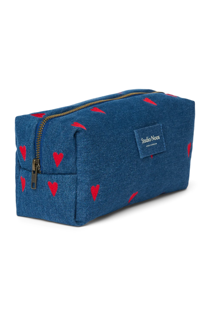 Seitenansicht: Seitenansicht der Pouch aus dunkelblauem Denim mit gestickten roten Herzen und Reißverschluss und Studio Noos Logo