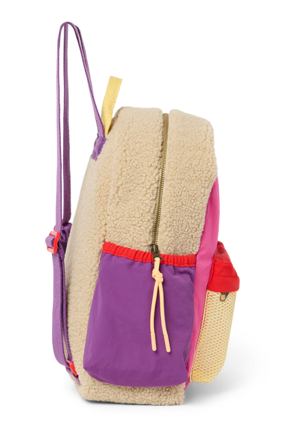 Seitenansicht: Studio Noos Patchwork Midi-Rucksack l Bright Pink in bunten Farben mit beigem Teddy-Stoff an den Seiten und an der Rückseite, pinken Patchwork-Details und lila-rot-beigen Akzenten