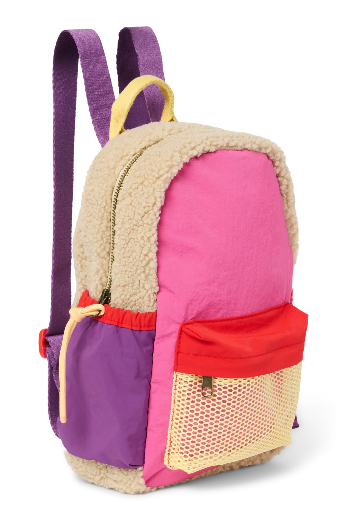 Seitenansicht: Studio Noos Patchwork Mini-Rucksack l Bright Pink mit Reissverschluss-Mesh-Tasche vorne und seitlichen Taschen. In bunten Farben mit beigem Teddy-Stoff, Patchwork-Details mit pink-rot-lila-beigen Akzenten. Lila Träger verstellbar und an der Rückseite ausschließlich beiger Teddystoff.