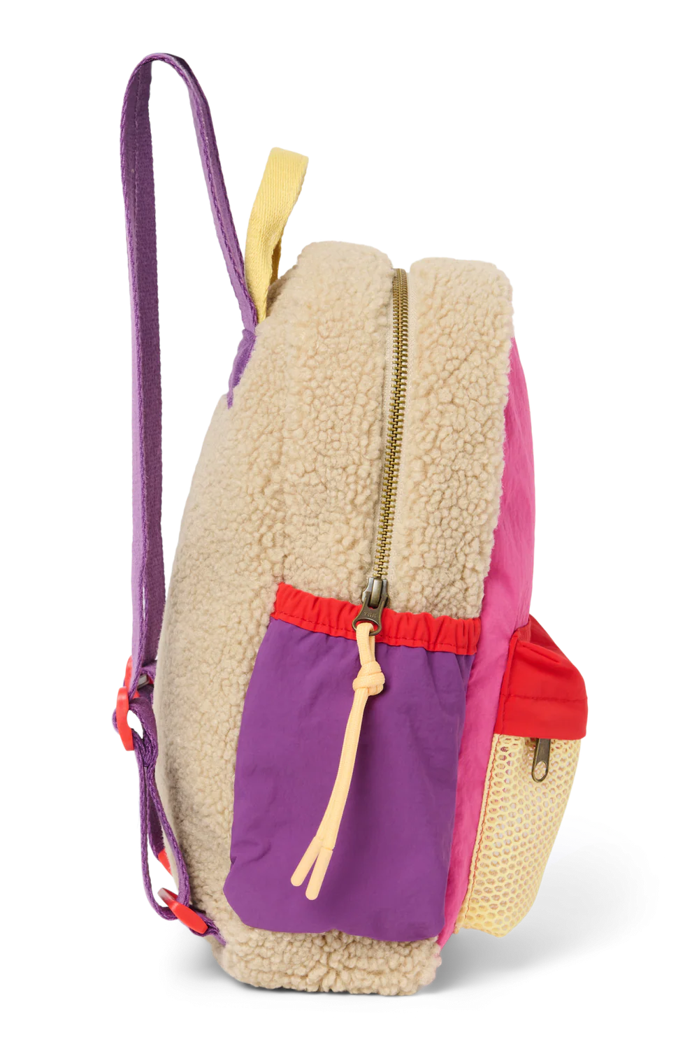 Seitenansicht: Studio Noos Patchwork Mini-Rucksack l Bright Pink mit Reissverschluss-Mesh-Tasche vorne und seitlichen Taschen. In bunten Farben mit beigem Teddy-Stoff, Patchwork-Details mit pink-rot-lila-beigen Akzenten. Lila Träger verstellbar und an der Rückseite ausschließlich beiger Teddystoff.