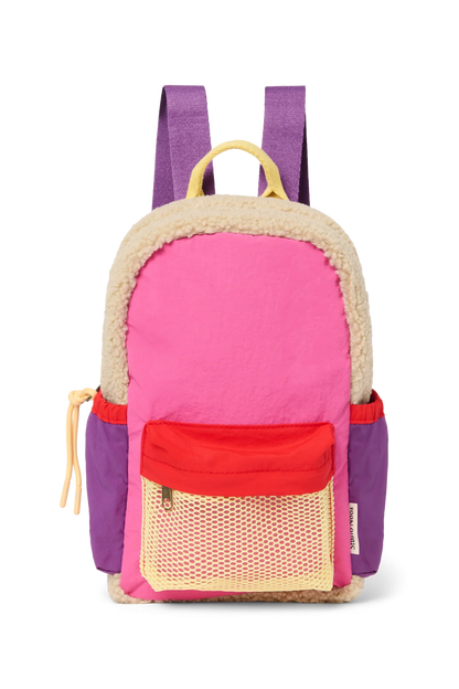 Vorderansicht: Studio Noos Patchwork Mini-Rucksack l Bright Pink mit Reissverschluss-Mesh-Tasche vorne und seitlichen Taschen. In bunten Farben mit beigem Teddy-Stoff, Patchwork-Details mit pink-rot-lila-beigen Akzenten. Lila Träger verstellbar und an der Rückseite ausschließlich beiger Teddystoff.