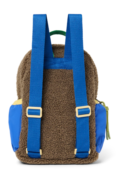 ansicht: Studio Noos Patchwork Mini-Rucksack l Fiery Red in bunten Farben mit braunem Teddy-Stoff, roten Patchwork-Details und blau-grün-gelben Akzenten. Rückseite aus braunem Teddystoff und blaue verstellbare Träger