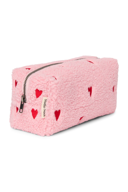 Seitenansicht der Studio Noos Pouch aus pinkem Teddystoff mit gestickten roten Herzen, Reißverschluss und Studio Noos Label