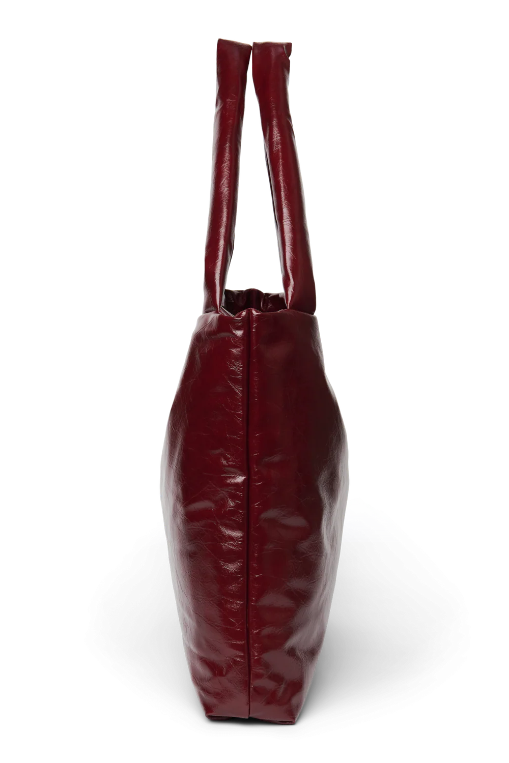 Seitenansicht: Studio Noos Vegan Leather Mom Bag in Bordeauxrot mit gepolsterten Griffen und kleinem Studio Noos Amsterdam Label vorne
