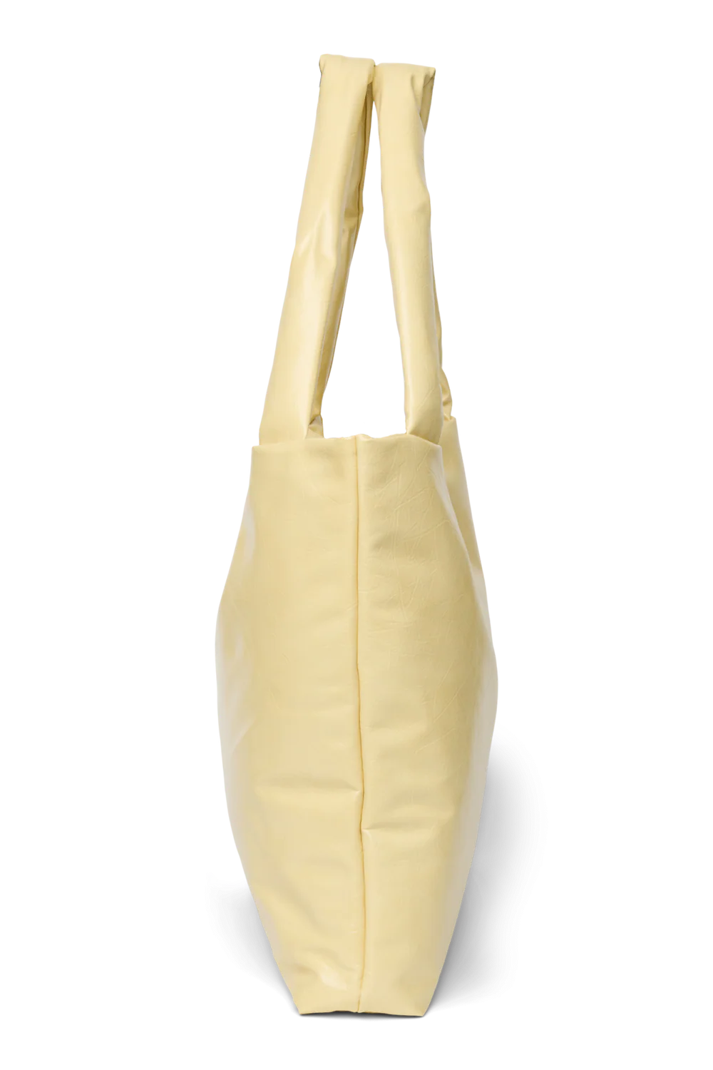 Seitenansicht: Studio Noos Vegan Leather Mom Bag in Buttergelb mit gepolsterten Griffen und kleinem Studio Noos Amsterdam Label vorne