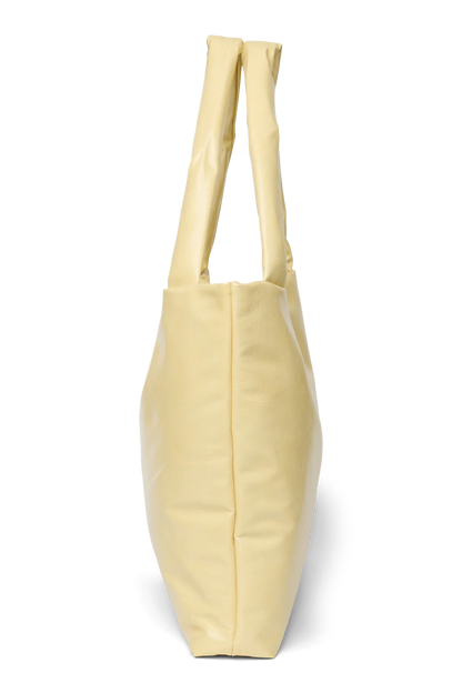 Seitenansicht: Studio Noos Vegan Leather Mom Bag in Buttergelb mit gepolsterten Griffen und kleinem Studio Noos Amsterdam Label vorne