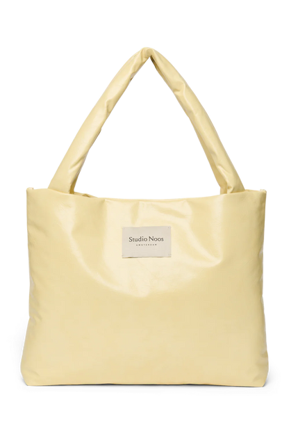 Vorderansicht: Studio Noos Vegan Leather Mom Bag in Buttergelb mit gepolsterten Griffen und kleinem Studio Noos Amsterdam Label vorne